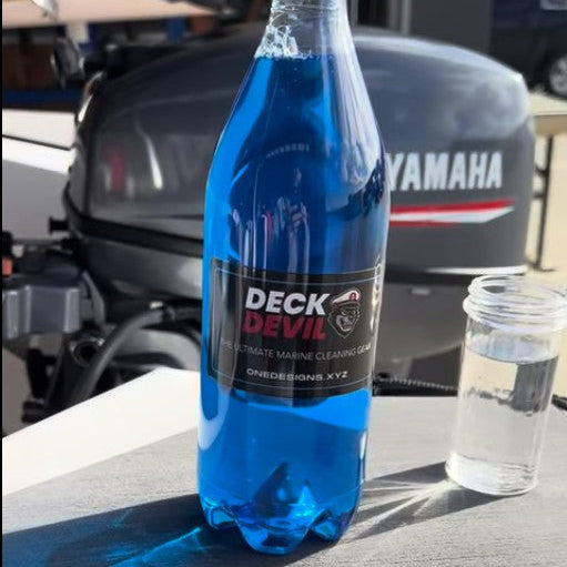 Blue bottle labeled 'Deck Devil Ultra Wash' on a table with a Yamaha boat motor in the background.